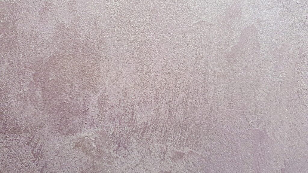 Decorative plaster of lilac color, with a silver coating. natural texture. selective focus.